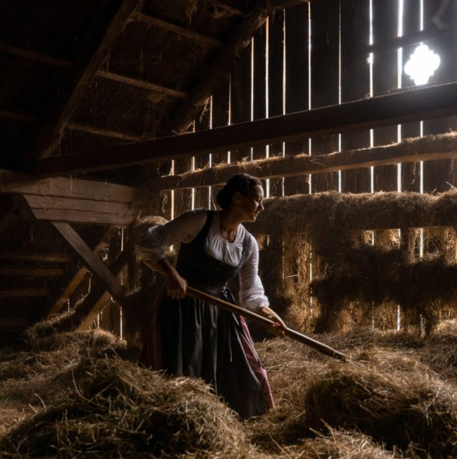 Sennerin im Stall am Bauernhof Lutzmannhof in Irdning, Steiermark